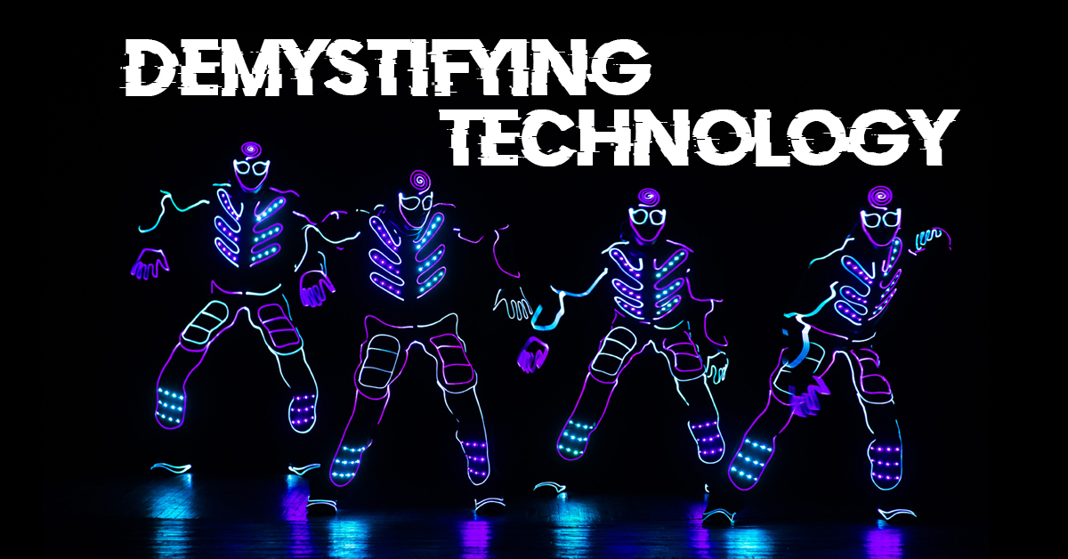 Four dancers in a line, with bright neon lit costumes